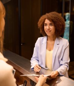 Elegant business woman filling form at counter