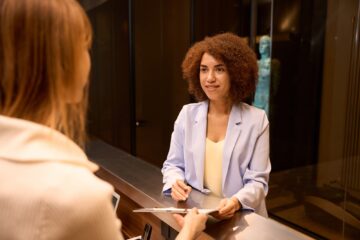 Elegant business woman filling form at counter